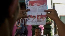 Ilustrasi seorang memperlihatkan kertas surat suara di TPS, foto dari laman https://nasional.tempo.co/