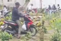 Warga Jember lintasi area pemakaman. (Sumber foto: tangkapan layar)