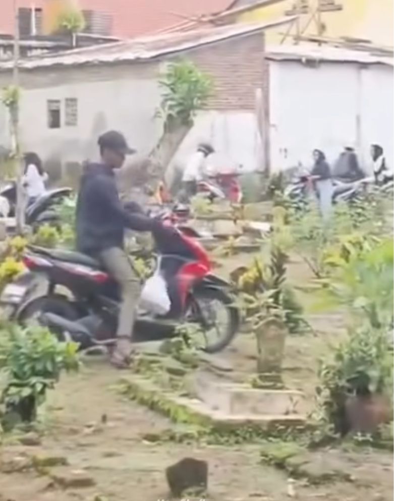 Warga Jember lintasi area pemakaman. (Sumber foto: tangkapan layar)