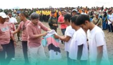 Bupati Jember, Muhammad Fawait membagikan kaos saat acara aksi bersih-bersih pantai di kawasan Pantai Selatan Jember. (Foto: Istimewa). 