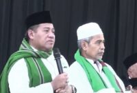 Gus Aab mengenakan peci hitam dan memegang mikrofon saat menyampaikan ceramah