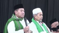 Gus Aab mengenakan peci hitam dan memegang mikrofon saat menyampaikan ceramah