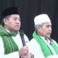 Gus Aab mengenakan peci hitam dan memegang mikrofon saat menyampaikan ceramah