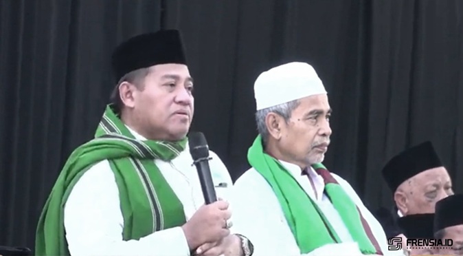 Gus Aab mengenakan peci hitam dan memegang mikrofon saat menyampaikan ceramah