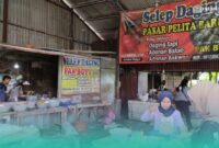 Karyawan yang sedang menakar adonan di Selep Daging di Pasar Pelita Baru, Kaliwates, Jember (Foto: Fadli/Frensia). 