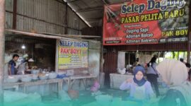 Karyawan yang sedang menakar adonan di Selep Daging di Pasar Pelita Baru, Kaliwates, Jember (Foto: Fadli/Frensia). 