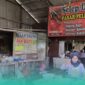 Karyawan yang sedang menakar adonan di Selep Daging di Pasar Pelita Baru, Kaliwates, Jember (Foto: Fadli/Frensia). 