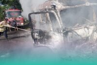 Petugas pemadam kebakaran saat memadamkan api di mobil travel yang terbakar (Foto: Damkarmat Jember). 