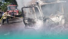 Petugas pemadam kebakaran saat memadamkan api di mobil travel yang terbakar (Foto: Damkarmat Jember). 