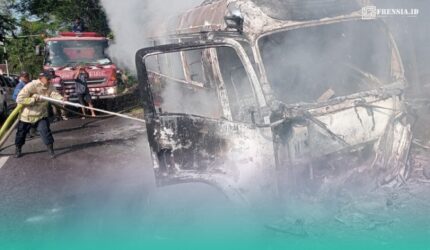 Petugas pemadam kebakaran saat memadamkan api di mobil travel yang terbakar (Foto: Damkarmat Jember).