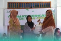 Ketua Dharma Wanita Persatuan UIN KHAS Jember, Luluk Sulthoniyah Hepni, saat menyalurkan bantuan ke masyarakat Karangmluwo (Foto: Humas UIN KHAS Jember). 