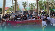 Massa aksi saat membentangkan poster dukungan pada Program MBG di depan Gedung DPRD Jember (Foto: Sigit/Frensia). 
