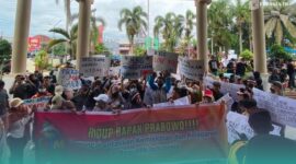Massa aksi saat membentangkan poster dukungan pada Program MBG di depan Gedung DPRD Jember (Foto: Sigit/Frensia). 