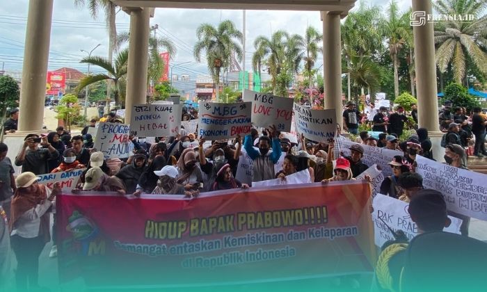 Massa aksi saat membentangkan poster dukungan pada Program MBG di depan Gedung DPRD Jember (Foto: Sigit/Frensia). 