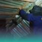 Petugas Damkar Jember saat melakukan evakuasi kucing yang terjepit di rumah warga (Foto: Istimewa). 