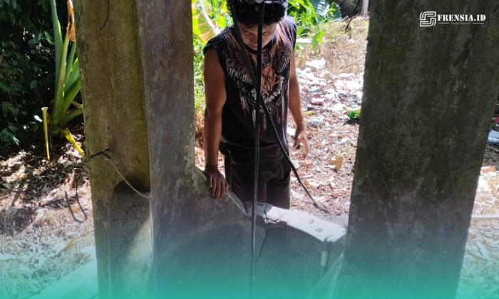 Tiyo Riski Setiawan, Adik Ketua RT Dusun Bunder, Desa Sumber Pinang, Kecamatan  Pakusari, Jember, saat melihat kondisi sumur yang telah mengalami kekeringan (Foto: Fadli/Frensia). 