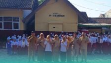 Guru SDN Jember Lor 06 sedang foto bersama siswa di depan gedung sekolah (Foto: Sigit/Frensia).  