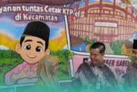 Direktorat Jenderal Kependudukan dan Pencatatan Sipil (Dirjen Dukcapil) Kementerian Dalam Negeri (Kemendagri) RI, Teguh Setyabudi (tengah), bersama Bupati Jember, Muhammad Fawait (kanan) saat menyerahkan KTP kepada salah satu warga desa (Foto: Fadli/Frensia). 