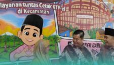 Direktorat Jenderal Kependudukan dan Pencatatan Sipil (Dirjen Dukcapil) Kementerian Dalam Negeri (Kemendagri) RI, Teguh Setyabudi (tengah), bersama Bupati Jember, Muhammad Fawait (kanan) saat menyerahkan KTP kepada salah satu warga desa (Foto: Fadli/Frensia). 