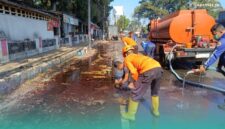 Petugas BPBD Kabupaten Jember, saat membersihkan tumpahan solar di depan Rest Area Jubung, Kecamatan Sukorambi (Foto: Humas BPBD Jember). 
