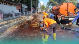 Petugas BPBD Kabupaten Jember, saat membersihkan tumpahan solar di depan Rest Area Jubung, Kecamatan Sukorambi (Foto: Humas BPBD Jember). 
