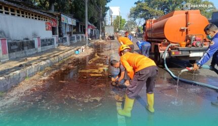 Petugas BPBD Kabupaten Jember, saat membersihkan tumpahan solar di depan Rest Area Jubung, Kecamatan Sukorambi (Foto: Humas BPBD Jember).