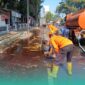 Petugas BPBD Kabupaten Jember, saat membersihkan tumpahan solar di depan Rest Area Jubung, Kecamatan Sukorambi (Foto: Humas BPBD Jember). 