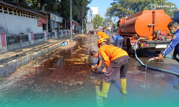 Petugas BPBD Kabupaten Jember, saat membersihkan tumpahan solar di depan Rest Area Jubung, Kecamatan Sukorambi (Foto: Humas BPBD Jember). 