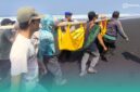 Warga setempat dan pihak kepolisian saat mengevakuasi korban yang meninggal terseret ombak (Foto: Istimewa). 