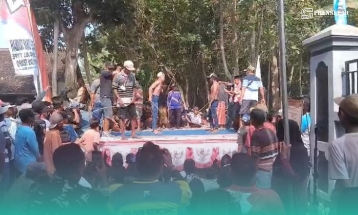Warga saat melakukan kegiatan saling cambuk dalam Festival Ojung, di Desa Cakru, Kecamatan Kencong, Jember (Foto: Istimewa). 