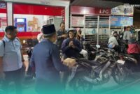 Bupati Jember, Muhammad Fawait saat membagikan makanan pada warga yang sedang antre mengisi bahan bakar minyak (BBM) di salah satu SPBU. (Foto: Sigit/Frensia). 