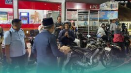 Bupati Jember, Muhammad Fawait saat membagikan makanan pada warga yang sedang antre mengisi bahan bakar minyak (BBM) di salah satu SPBU. (Foto: Sigit/Frensia). 