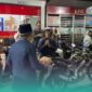 Bupati Jember, Muhammad Fawait saat membagikan makanan pada warga yang sedang antre mengisi bahan bakar minyak (BBM) di salah satu SPBU. (Foto: Sigit/Frensia). 