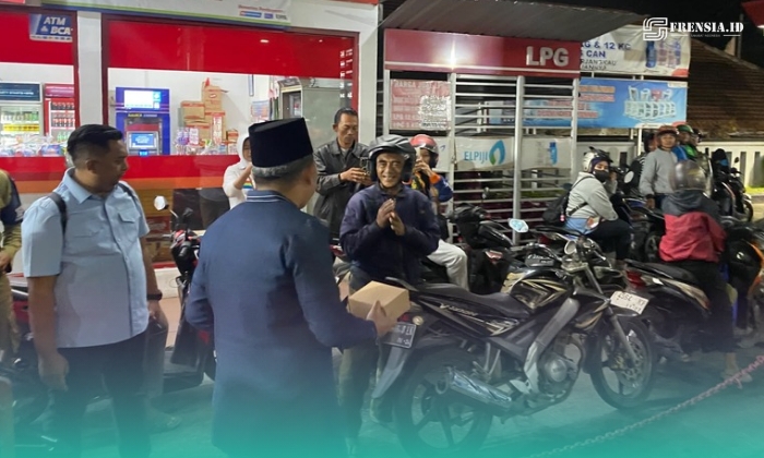 Bupati Jember, Muhammad Fawait saat membagikan makanan pada warga yang sedang antre mengisi bahan bakar minyak (BBM) di salah satu SPBU. (Foto: Sigit/Frensia). 