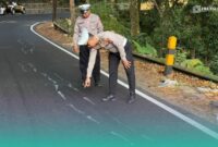 Petugas Satlantas Polres Jember saat mengecek kondisi jalan  raya jalur Jember-Banyuwangi yang retak. (Foto: Istimewa). 