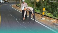 Petugas Satlantas Polres Jember saat mengecek kondisi jalan  raya jalur Jember-Banyuwangi yang retak. (Foto: Istimewa). 