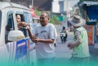 Petugas Satlantas Polres Jember, saat membagikan sembako dan nasi bungkus ke warga Jember. (Foto: Istimewa). 