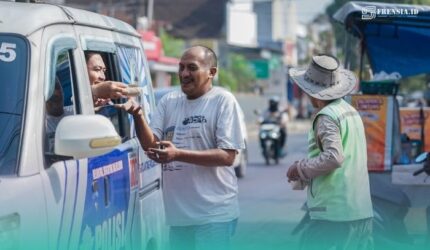 Petugas Satlantas Polres Jember, saat membagikan sembako dan nasi bungkus ke warga Jember. (Foto: Istimewa).