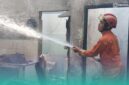 Petugas pemadam kebakaran (Damkar) Jember, saat memadamkan api di sela-sela keramik rumah yang terbakar. (Foto: Istimewa). 