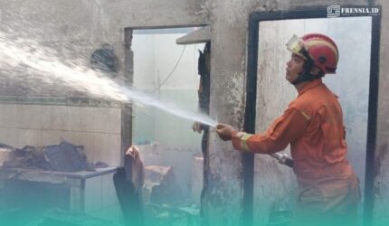 Petugas pemadam kebakaran (Damkar) Jember, saat memadamkan api di sela-sela keramik rumah yang terbakar. (Foto: Istimewa).