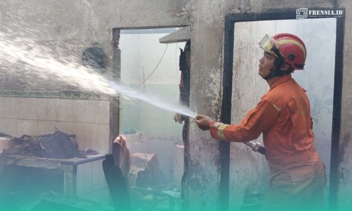 Petugas pemadam kebakaran (Damkar) Jember, saat memadamkan api di sela-sela keramik rumah yang terbakar. (Foto: Istimewa). 