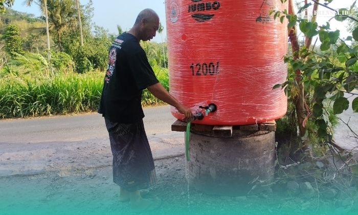 Ketua RT 001/RW 006, Dusun Kasengan, Desa Gumuksari, Kecamatan Kalisat, Suhermanto, saat mengecek kondisi tandon, setelah diisi ulang air bersih oleh BPBD Jember. (Foto: Fadli/Ketik.com).