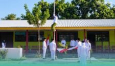 Wakil Sekretaris PCNU Situbondo, Gus Lukman Hakim, saat memanjat tiang bendera di upacara Peringatan Hari Santri Nasional 2026. (Foto: Istimewa). 