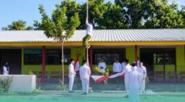 Wakil Sekretaris PCNU Situbondo, Gus Lukman Hakim, saat memanjat tiang bendera di upacara Peringatan Hari Santri Nasional 2026. (Foto: Istimewa). 