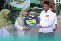 Iffah Jauharoh Dina Salsabila, Mahasiswa Program Studi Manajemen Bisnis Syariah Fakultas Ekonomi dan Bisnis Islam (FEBI) UIJ, angkatan 2025, saat menerima Beasiswa Tahfidz, dari Rektor Universitas Islam Jember (UIJ), Ahmad Halid (kanan). (Foto: Humas UIJ).